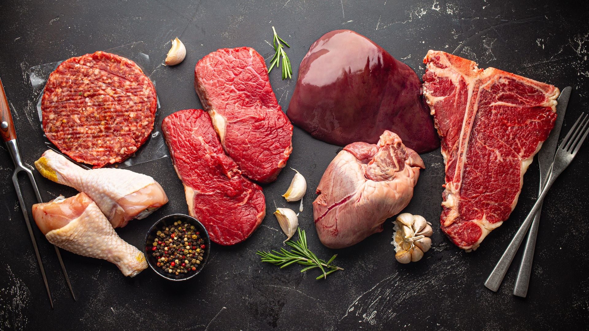 Different cuts of meat on a dark background