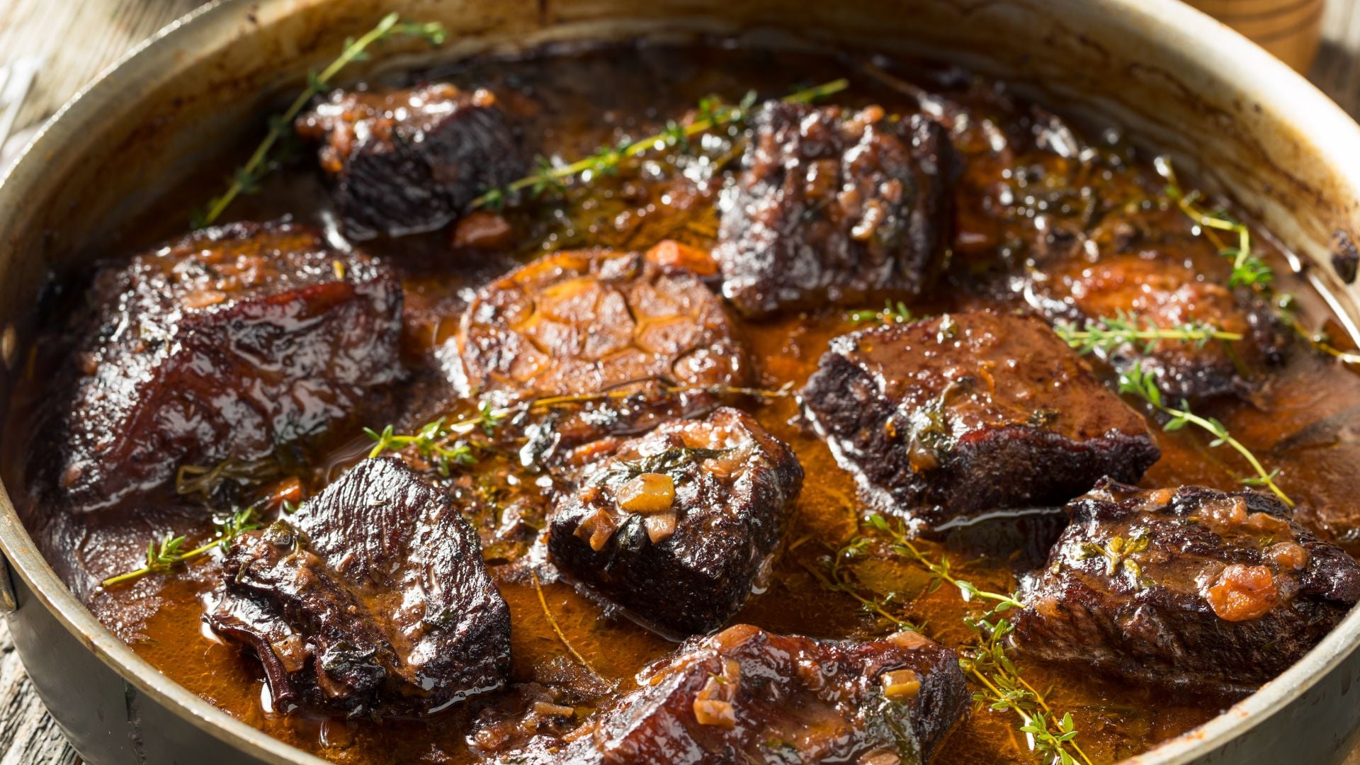 Properly browned meat braising in liquid with herbs.